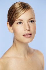 Fototapeta premium Blue eyed beautiful woman against blue background