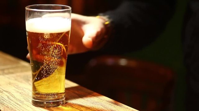 Close up footage of a beer glass on a counter in a pub or restaurant.
