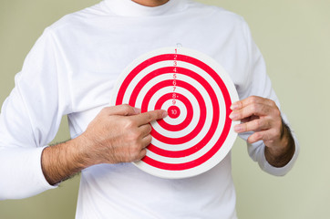 A man's finger pointing to the center of red circle with number; target sign