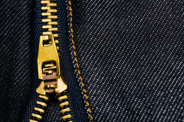 Metal zipper openning on blue jean texture with copy space.