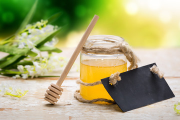 Honey in jar on wooden table.
