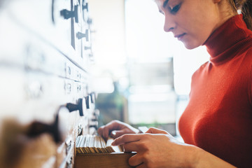 Young librarian opens library card index