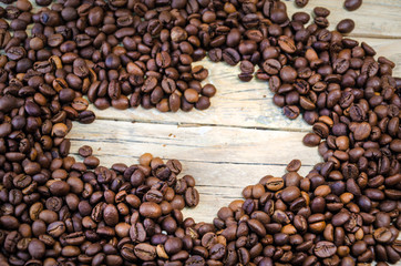 Arrow of coffee. Roasted Coffee beans on natural wooden background
