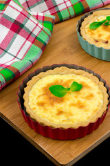 Two homemade quiche with chicken, cheese, cream, onion and mint on wooden background. Above