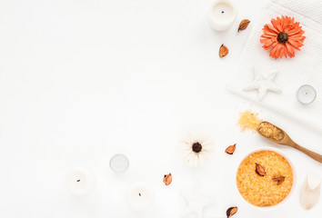 Spa composition. Sea salt, orange flowers, spa candles, bath towel on white background. Flat lay, top view