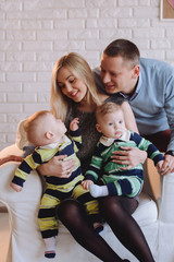Happy family portrair. Parents with baby two boys twins.Portrait of happy family with two children smiling at camera.