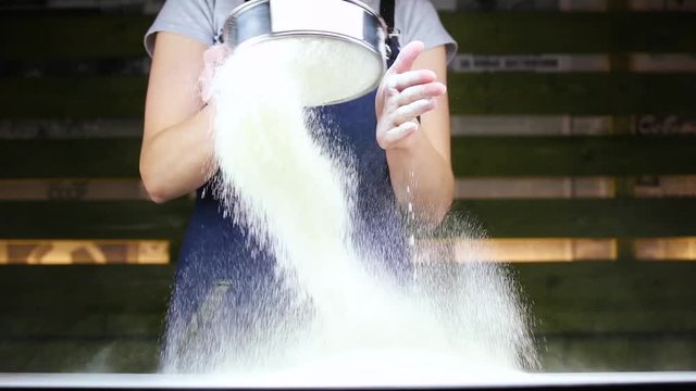 woman cook sifts the flour through sieve