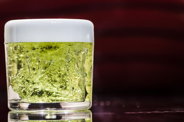 Transparent jar with green gel inside closed with a white lid