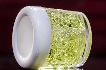 Transparent jar with green gel inside closed with a white lid