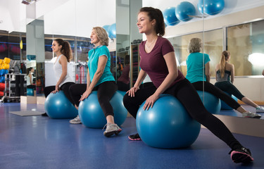 Different age women jumping on exercise ball