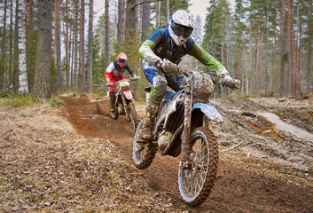Motocross drivers in competition on the enduro race track - obrazy, fototapety, plakaty