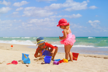 kids play with sand on summer beach