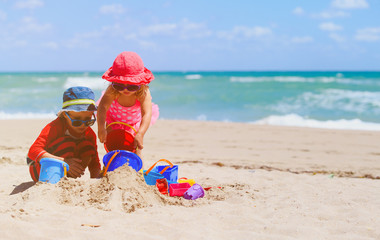 kids play with sand on summer beach