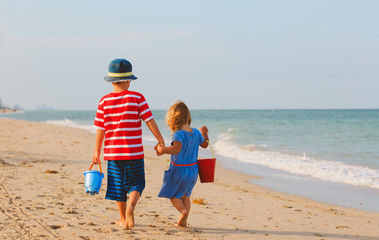 little boy and girl walking on beach