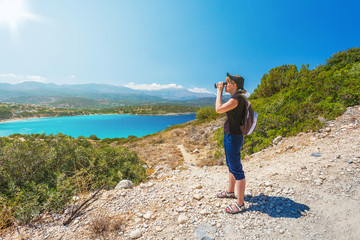 Traveling girl watching with binoculars on the sea background
