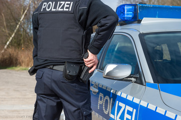 Polizist mit Hand an der Dienstwaffe
