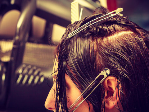 Hairdresser cutting woman dark long hair