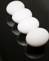 Eier mit Spiegelung auf schwarzem Hintergrund zu Ostern, Hochformat