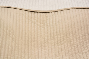 Close up of beige bed cover comforter