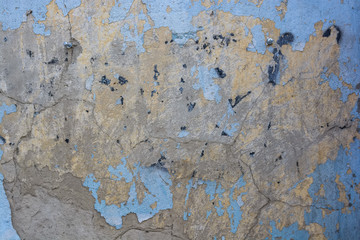 Blue cracked painting on old plaster wall surface