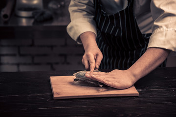 Chef cutting the fish on a board