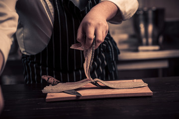 Chef cutting the fish on a board