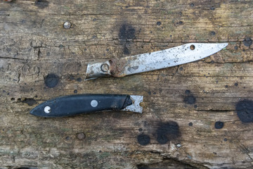 Close up of old rusty knife on wooden background