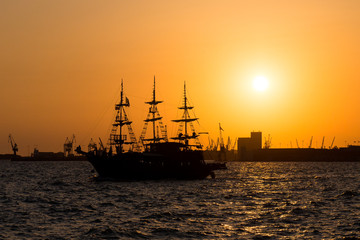 Ship at sunset. Tourist boat in the sea in the rays of the setting sun