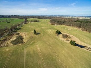 Obraz premium Aerial view of a green rural area agricultural fields under blue sky in germany
