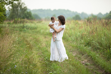 happy young mother with toddler in  arms walking