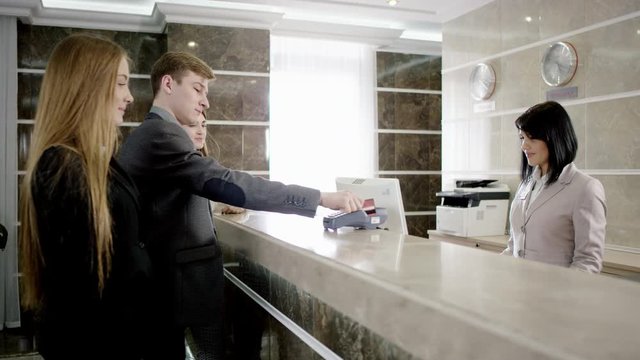 travellers paying for appartament in the hotel at the reception