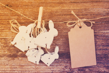 hanging easter rabbits with empty paper note , retro toned