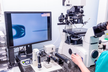 Embryologist adding sperm to egg in laboratory of reproductive clinic. Selective focus