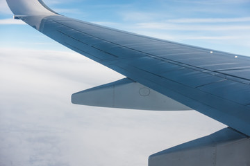 Wing of an aircraft and cloudy sky