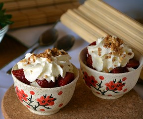 Refreshing snack chopped strawberries and whipped cream on a nice bowl.