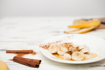 A bunch of bananas and a cut banana on a plate.