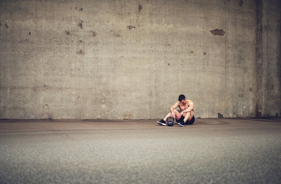 Tired athlete resting next to kettlebell