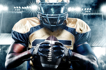 American football sportsman player on stadium with lights on background