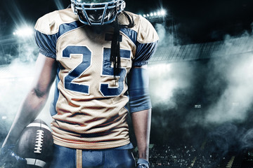 American football sportsman player on stadium with lights on background