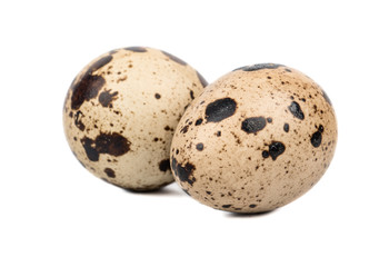 Two raw spotted quail eggs isolated on white background