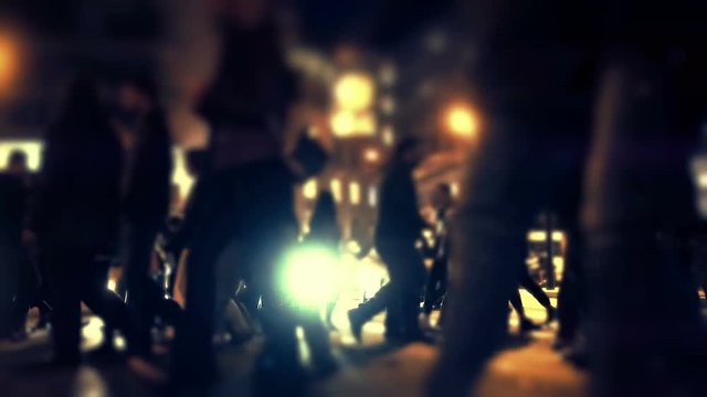 Silhouetted group of pedestrians cross busy big city street at night slomo.