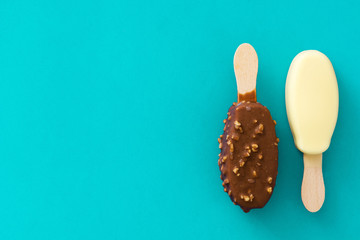 Black and white chocolate ice cream popsicles on blue background. 
