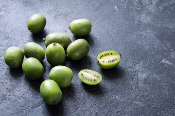 Foto op Plexiglas Baby kiwi or mini kiwi fruits on stone background. Closeup view © Vladislav Noseek