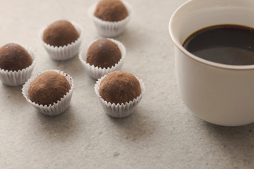 HOmemade cocoa truffles with cup of coffee