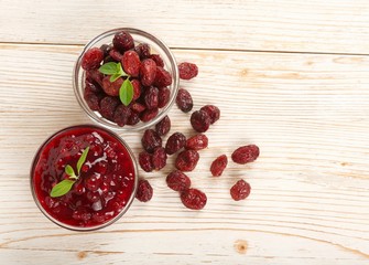 dry cranberries and jam on a wooden background