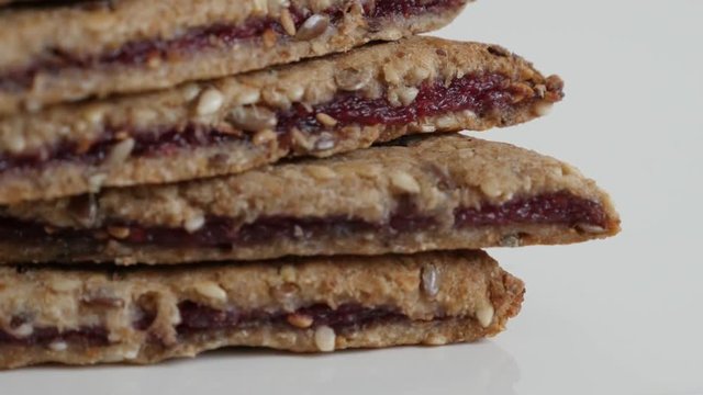 Tasty chrono food snack on white background 4K 2160p 30fps UltraHD tilting footage - Close-up of raspberry energy bars with assorted cereals slow tilt 3840X2160 UHD video