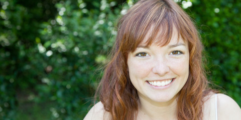 beautiful woman with red hair in park or garden