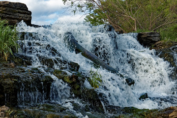 The water rushes over the Lake MacBride Waterfall. This waterfall has several main falls and...