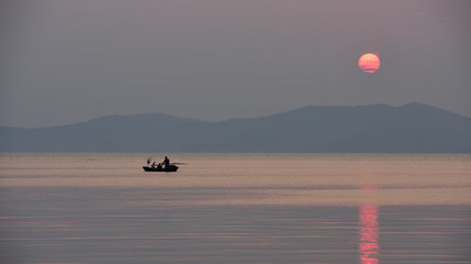 Fishman, Boat, Hill and Sunset in Taihu, Wuxi, Jiangsu provinve of China. Tai lake. Quiet peaceful.