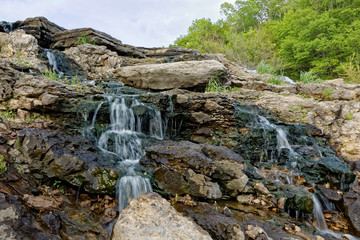 Fototapeta premium The water rushes over the Lake MacBride Waterfall. This waterfall has several main falls and numerous smaller falls.